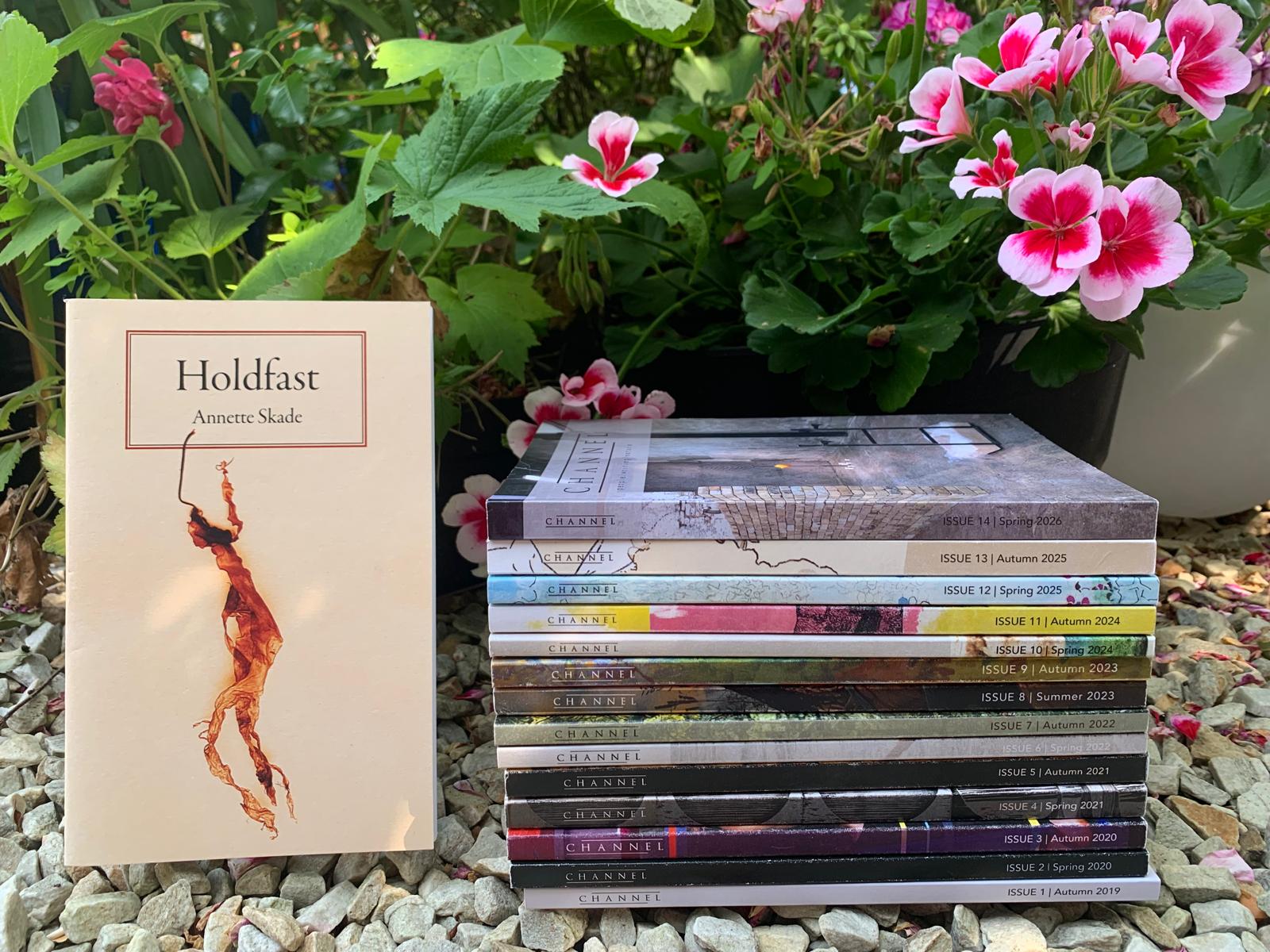 A photo of a book titled Holdfast with a stylised photo of a piece of seaweed on the front cover, beside a pile of issues of Channel